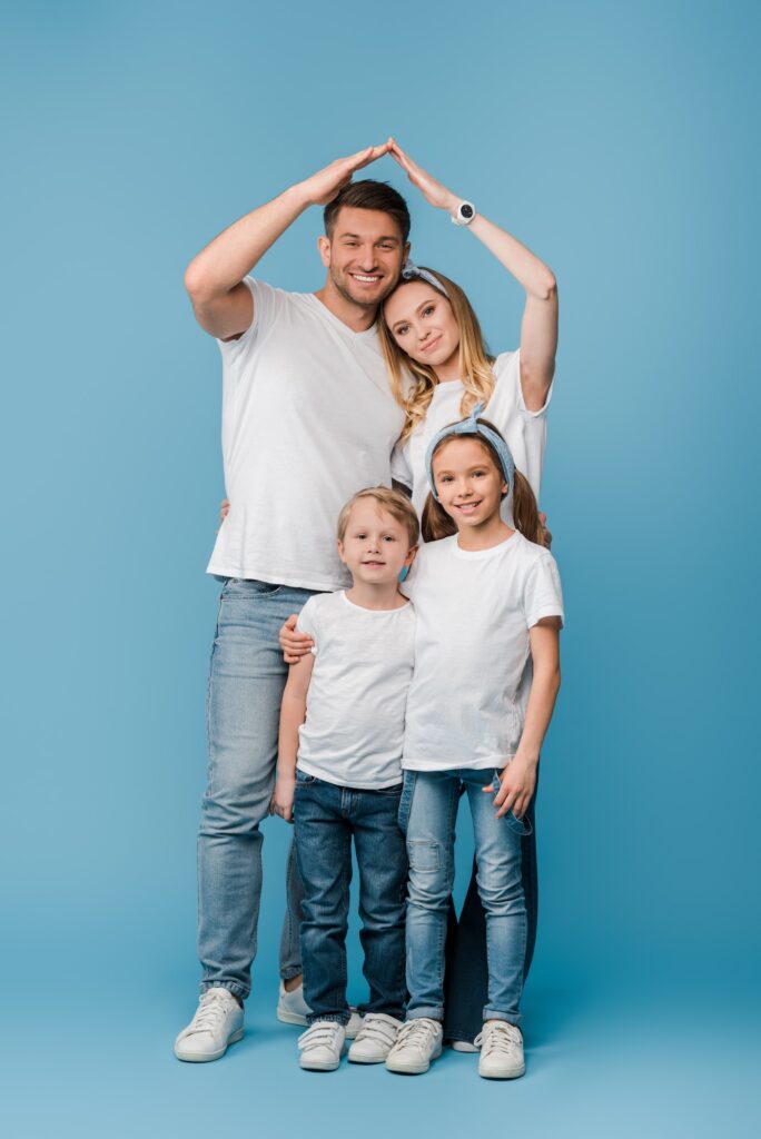 happy family with kids making roof gesture over heads on blue