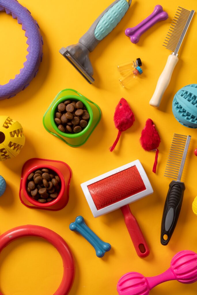 Pet care concept, various pet accessories on yellow background , flat lay